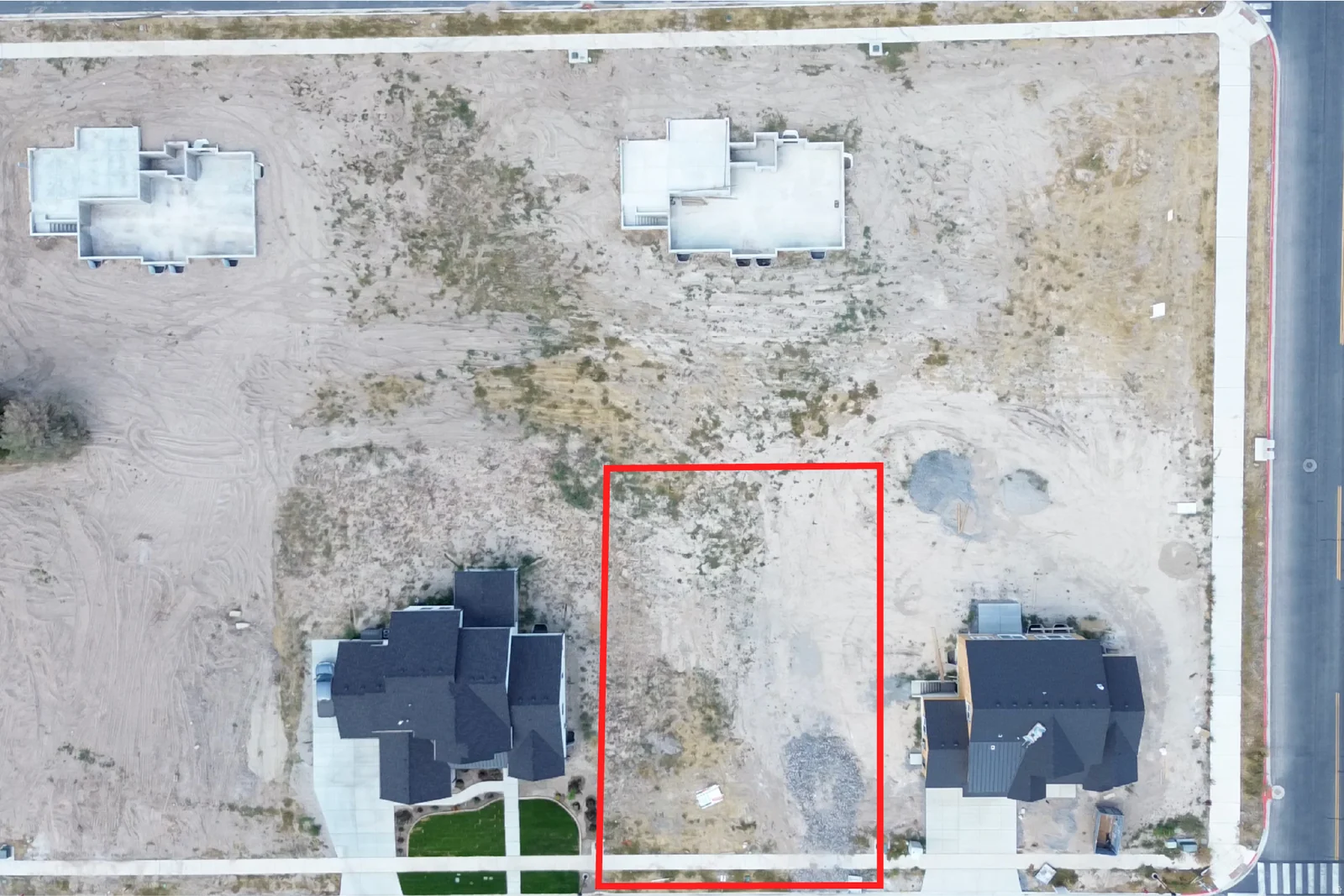 Expansive building lot featuring street frontage, existing sidewalks, and established neighboring properties